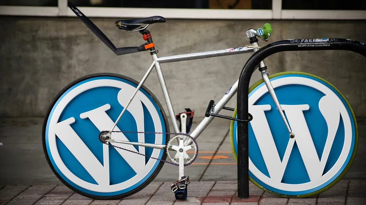 Pyörätelineeseen lukittu polkupyörä, jonka renkaina on WordPress-logot